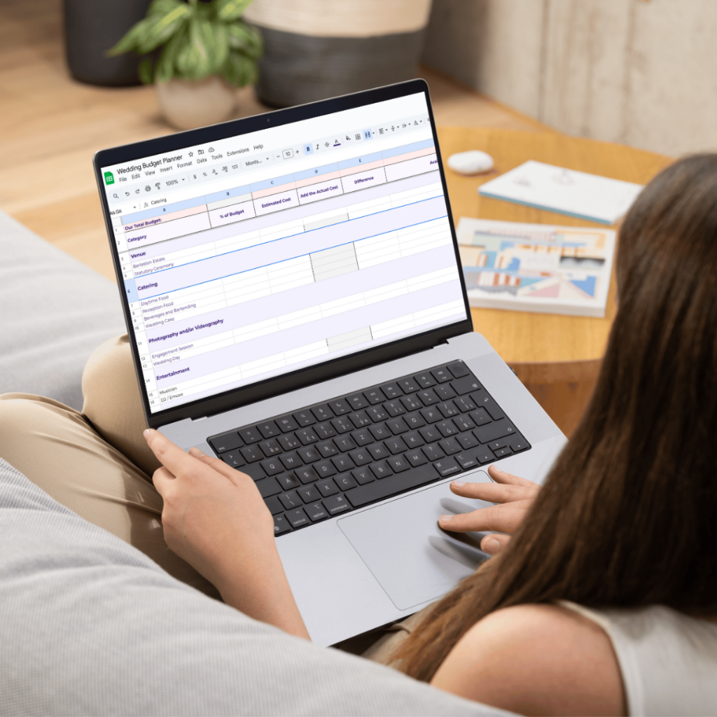 A woman using the Wedding Budgeting Guide on her laptop while sitting on her couch. 
