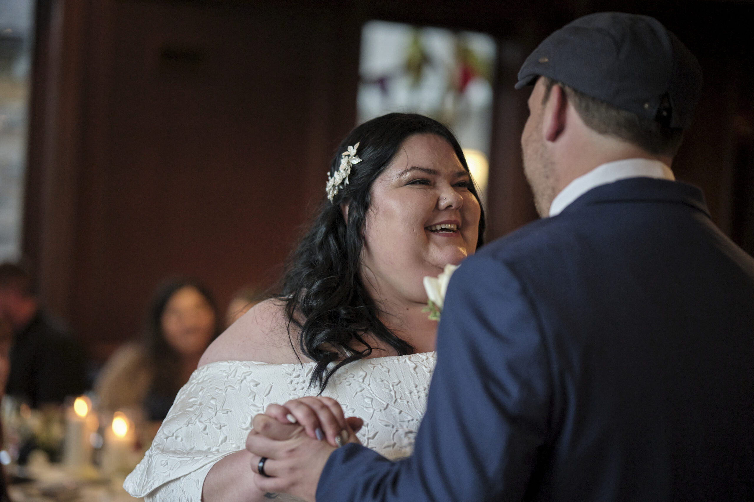 Bride and groom captured in a candid moment during their first dance by That Photographer Couple - Southern Ontario wedding photographers