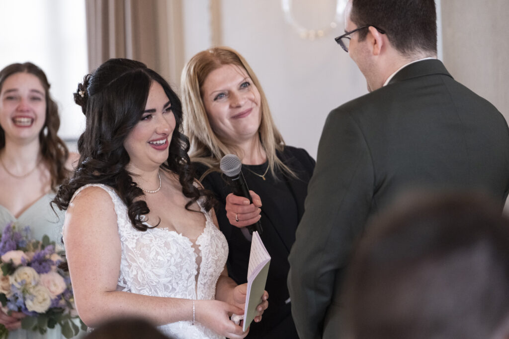 The bride laughs during her grooms vows at their wedding ceremony at the Elora Mill Foundry Chapel, in Elora, Ontario. 
