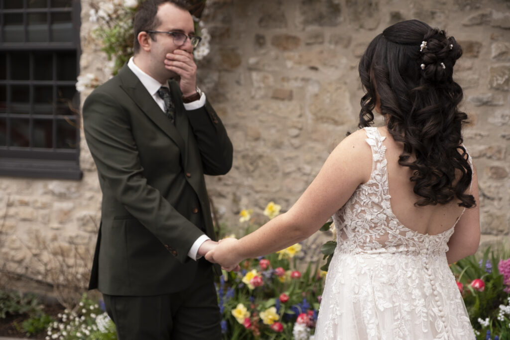 The groom reacts to his bride in his first look at her beauty on their wedding day at the Elora Mill, in Elora Ontario.
