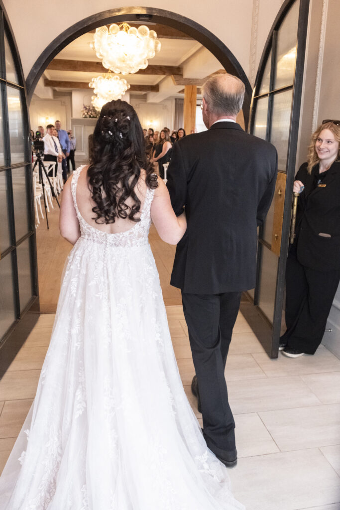 The bride and her father start their walk down the aisle at the Elora Mill Foundry Chapel in Elora, Ontario. 
