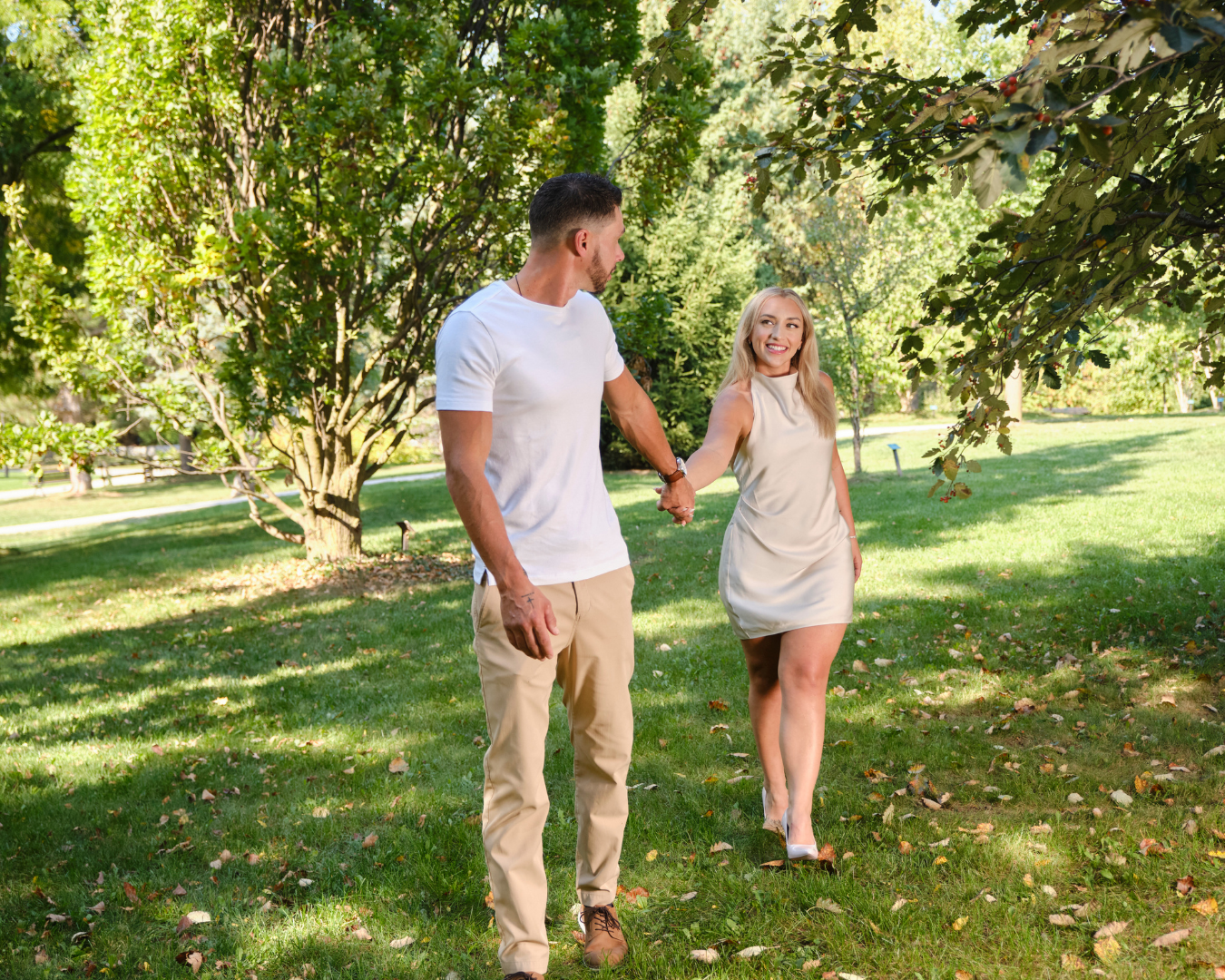 Couple walking hand in hand during a fall engagement session at the Collingwood Arboretum in Collingwood, Ontario.