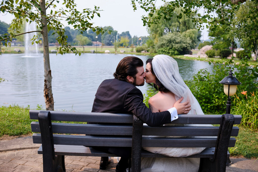 Couple on the bench in the summer garden at Nottawasaga Inn Resort & Conference Centre during their wedding day in Alliston, Ontario.